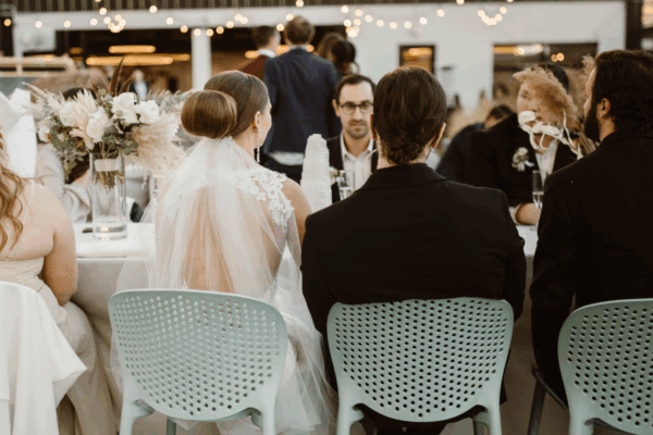 Newlywed couple smiling during rooftop wedding dinner at Rooftop1630 in Denver