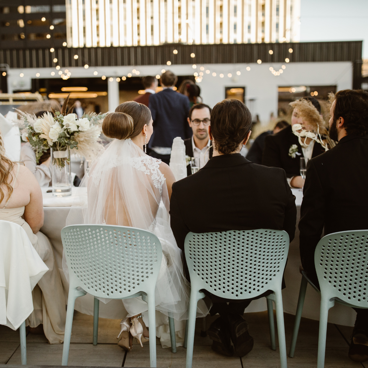Newlywed couple smiling during rooftop wedding dinner at Rooftop1630 in Denver